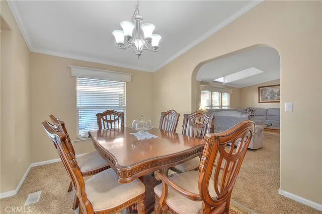 a view of a dining room with furniture a chandelier and wooden floor