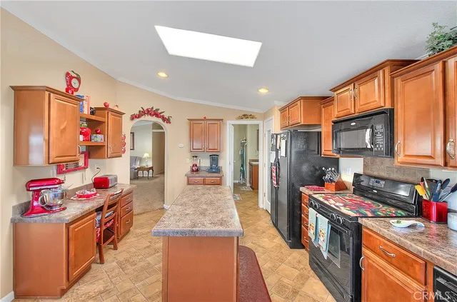 a kitchen with stainless steel appliances granite countertop a stove top oven a sink dishwasher and a refrigerator