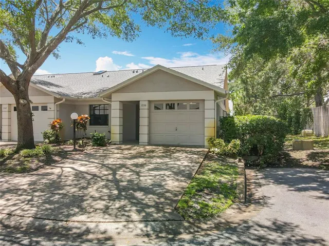 a view of a house with a yard and large tree