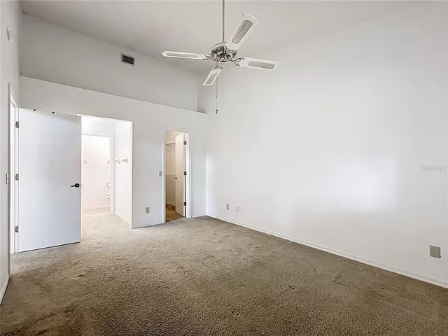 an empty room with a ceiling fan and a window