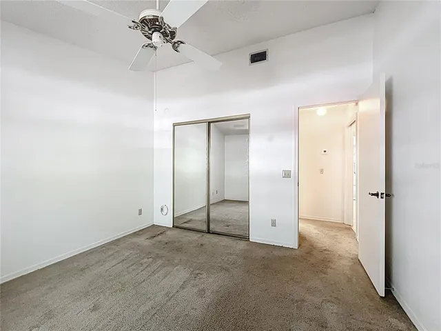an empty room with fan and entrance