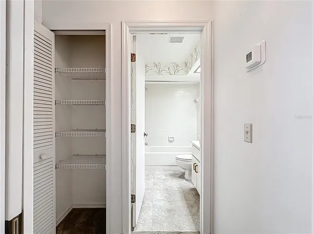 a bathroom with a walk in closet and a bathroom