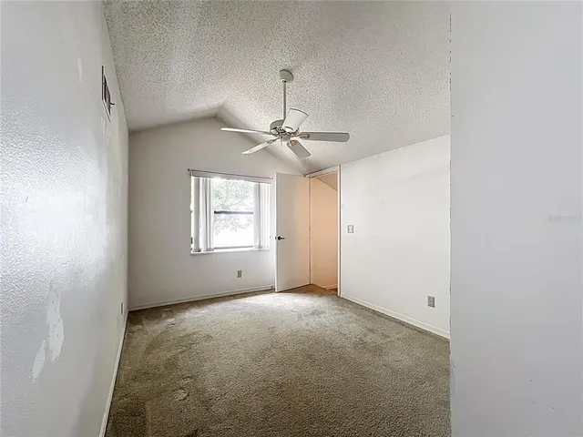 a view of a room with a ceiling fan and window