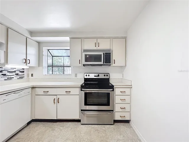 a kitchen with cabinets stainless steel appliances and sink