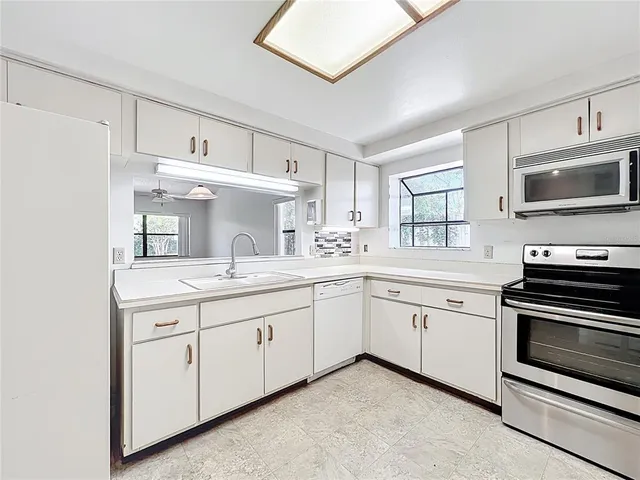 a kitchen with a sink stove and microwave