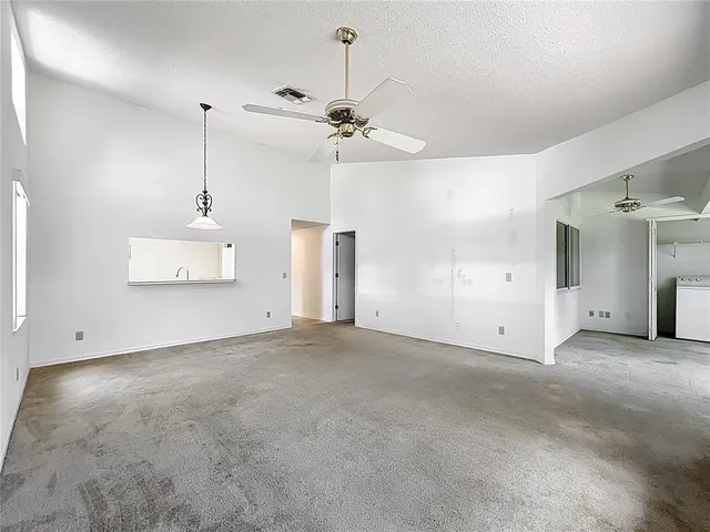 a view of an empty room with a ceiling fan