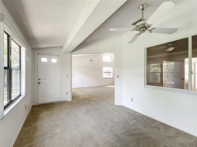 a view of a room with a ceiling fan and window