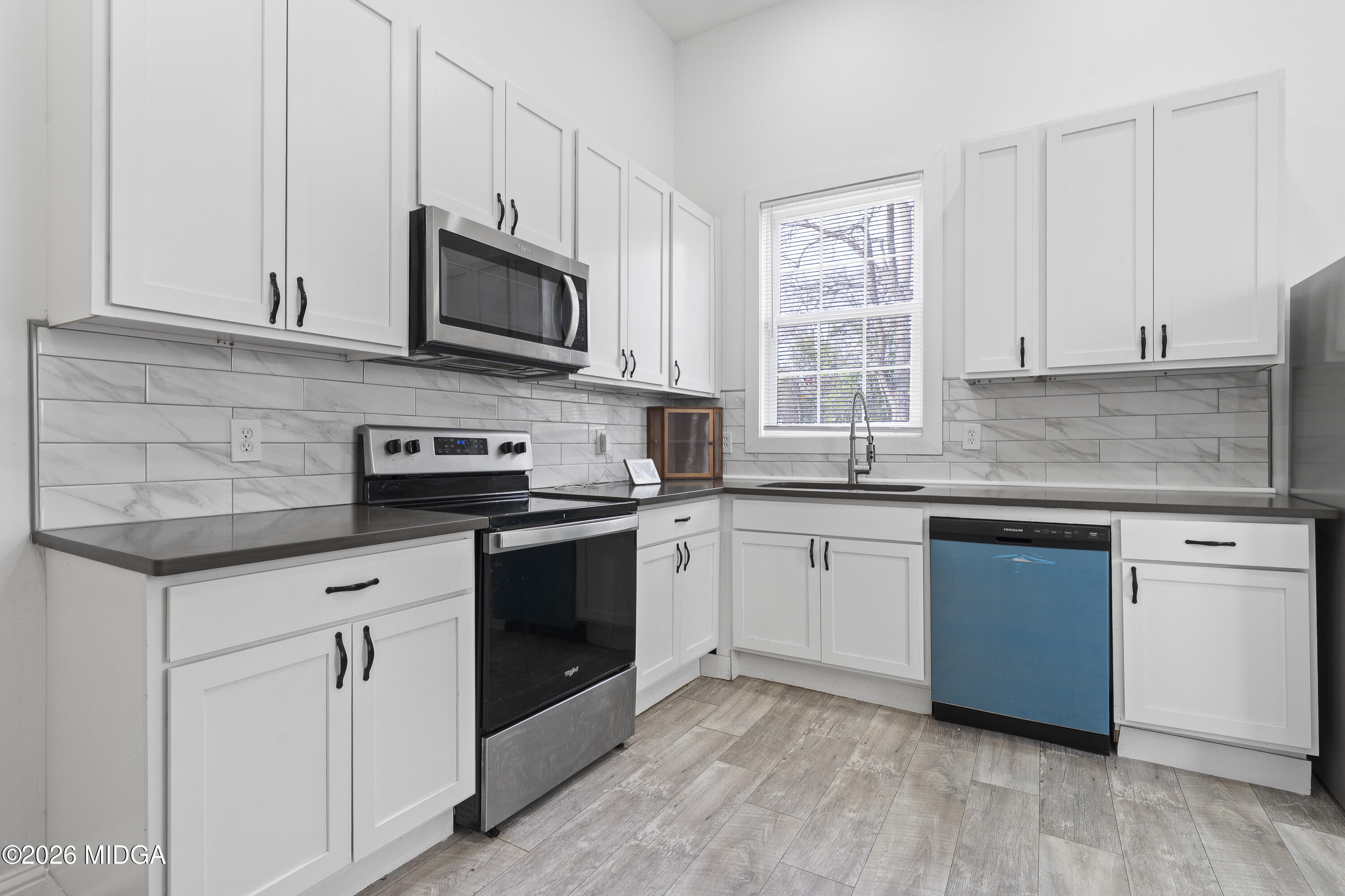 1471 Jackson Street Macon, GA 31201 - Photo 12 of 31 a kitchen with granite countertop white cabinets stainless steel appliances and a sink