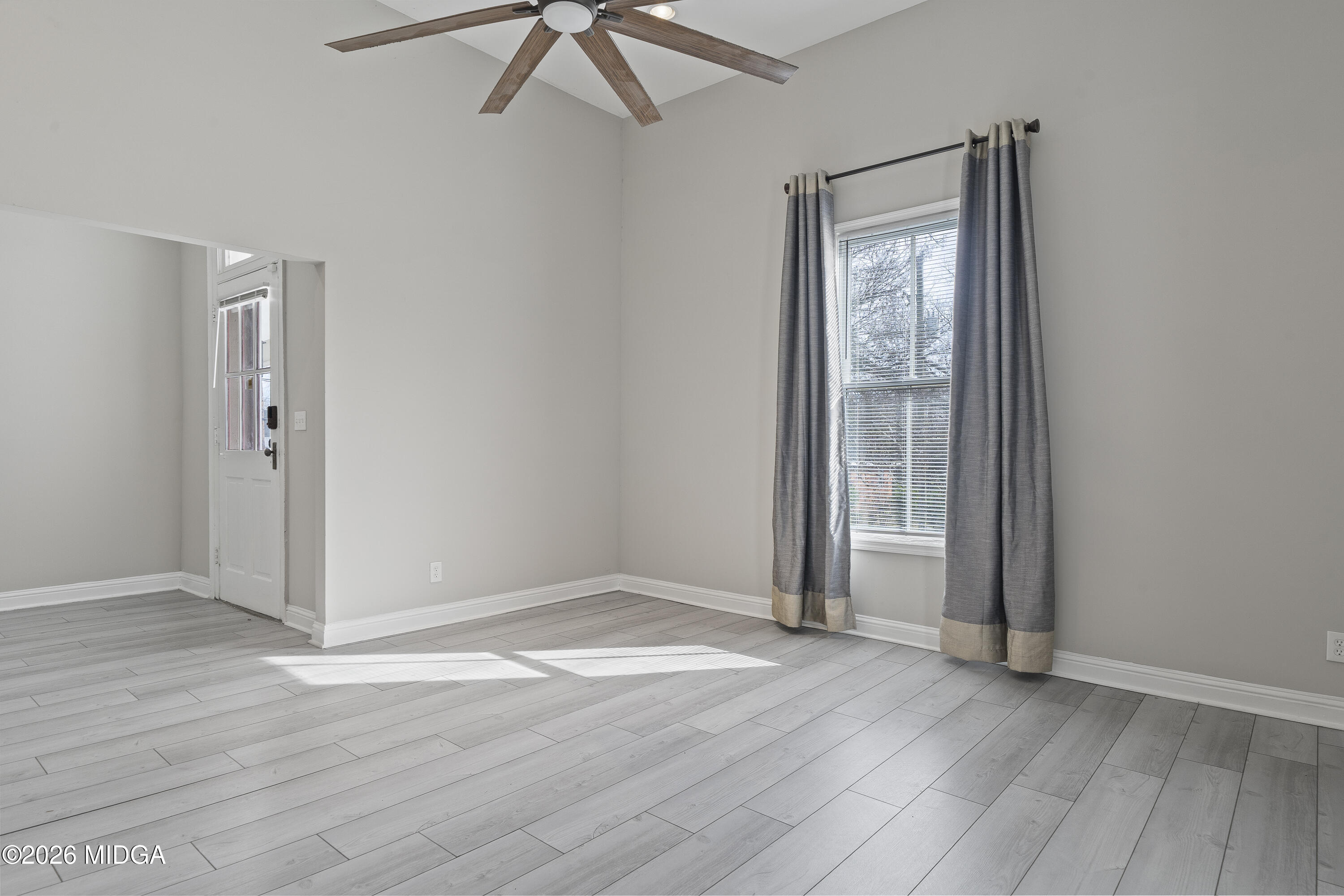 1471 Jackson Street Macon, GA 31201 - Photo 10 of 31 an empty room with wooden floor fan and windows