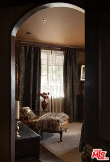 a bedroom with a bed and large windows