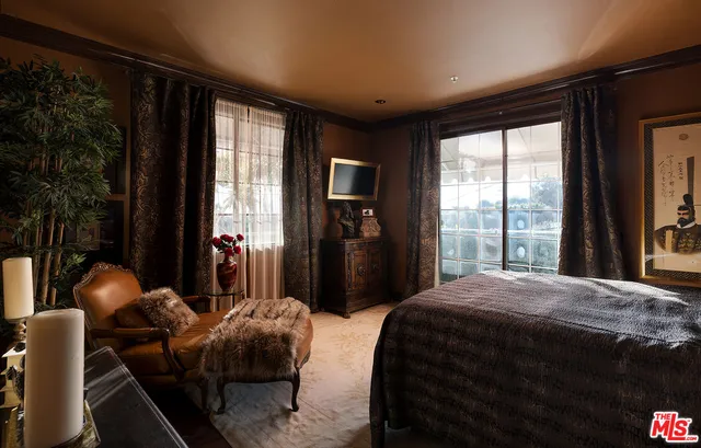 a bedroom with a large bed and wooden floor