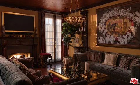 a living room with furniture a chandelier and a painting