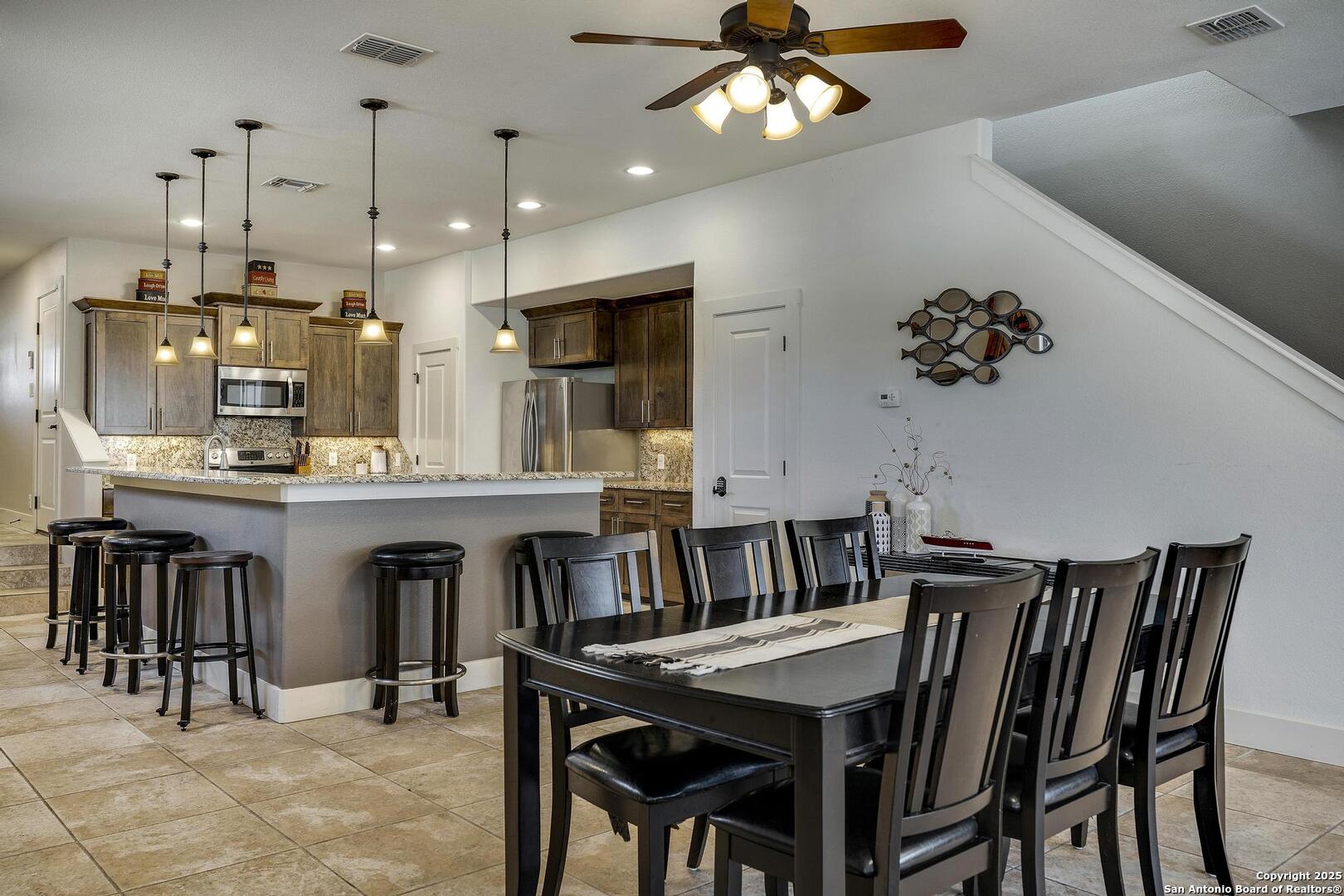 630 3 Oaks Road Seguin, TX 78155 - Photo 11 of 31 a kitchen with kitchen island a dining table chairs cabinets and stainless steel appliances