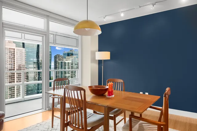 a view of a dining room with furniture a chandelier and wooden floor
