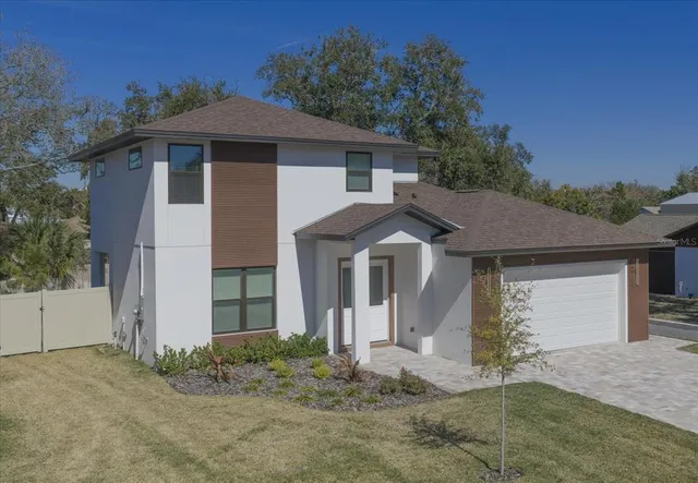 a view of a yard in front of a house with a large tree