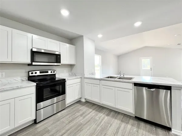 a kitchen with wooden cabinets and white appliances