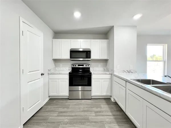 a kitchen with a sink stove and microwave
