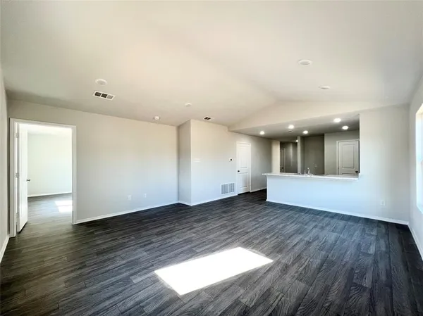 a view of an empty room with wooden floor