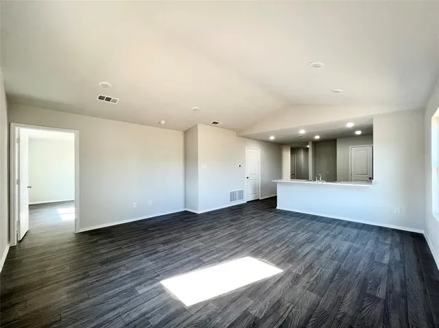 a view of an empty room with wooden floor