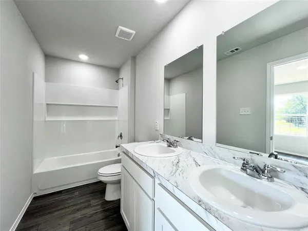 a bathroom with a granite countertop sink a toilet and a large mirror