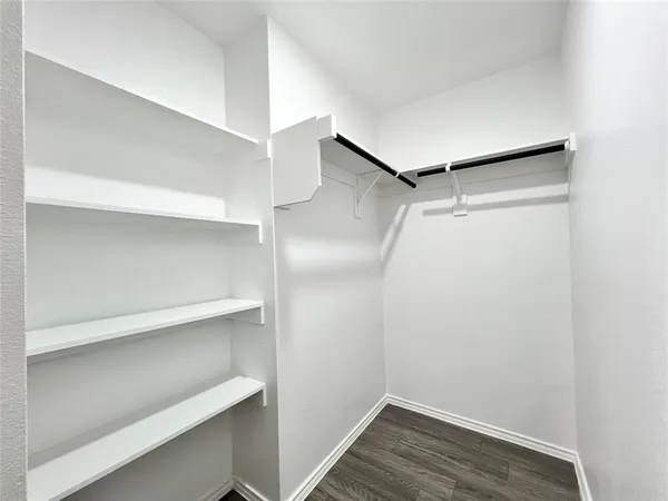 a view of walk in closet with empty racks