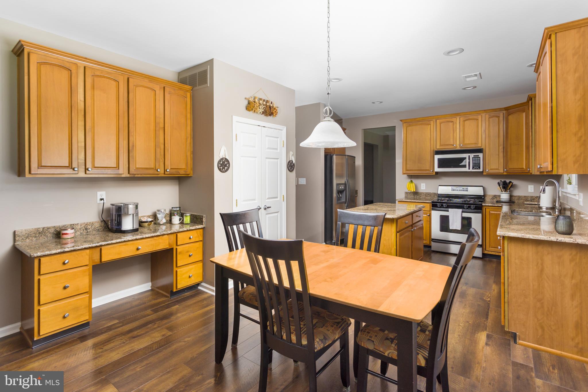 59 Birmingham Drive Columbus, NJ 08022 - Photo 15 of 45 a kitchen with stainless steel appliances granite countertop wooden floor a dining table and chairs