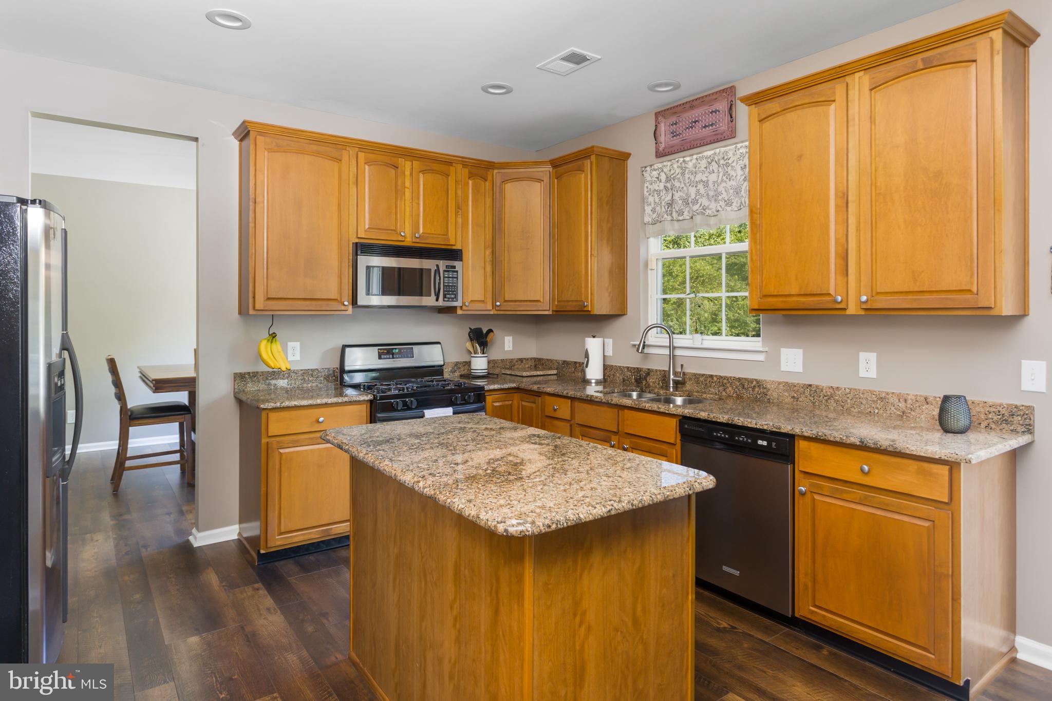 59 Birmingham Drive Columbus, NJ 08022 - Photo 17 of 45 a kitchen with a stove a sink a microwave a refrigerator and wooden cabinets