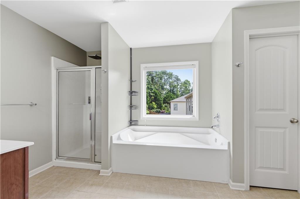 5825 Willow Oak Pass Cumming, GA 30040 - Photo 29 of 55 a bathroom with a bathtub and a shower