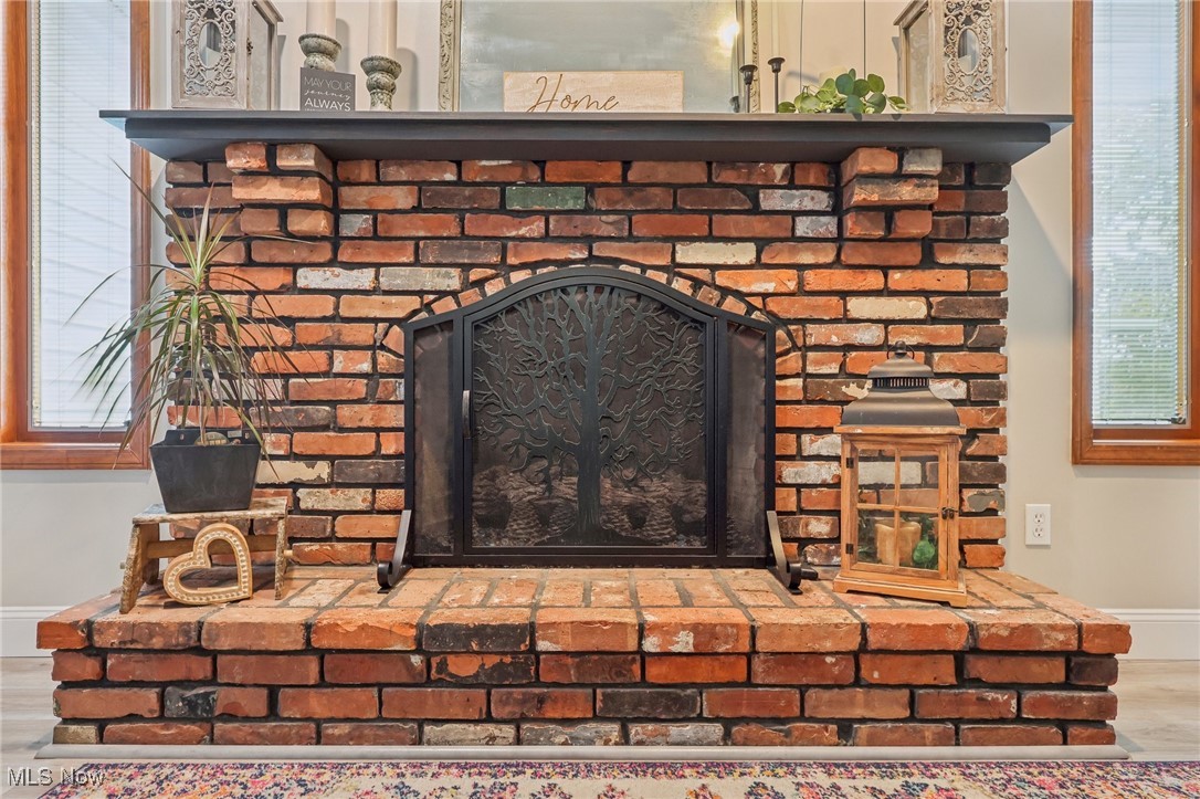 5418 River Road Madison, OH 44057 - Photo 26 of 43 Interior details featuring a brick fireplace and wood-type flooring