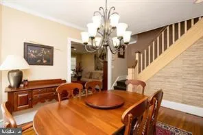 a dining room with furniture a chandelier and wooden floor
