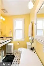 a bathroom with a granite countertop sink and a window