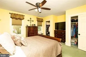 a bedroom with a bed and a flat tv screen on dresser