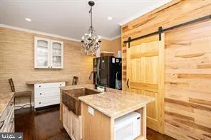 a kitchen that has a kitchen island furniture and a chandelier
