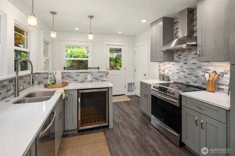 a kitchen with stainless steel appliances granite countertop a sink stove and cabinets