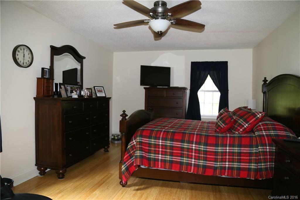 113 Sawtooth Lane, Unit 27 Stanley, NC 28164 - Photo 13 of 24 a bedroom with a bed and dresser with mirror