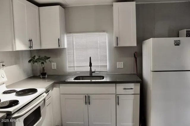 a kitchen with a sink a refrigerator and cabinets