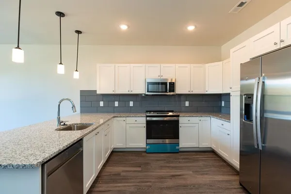 a kitchen with stainless steel appliances granite countertop a sink stove and refrigerator