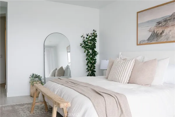 a bedroom with bed and a potted plant
