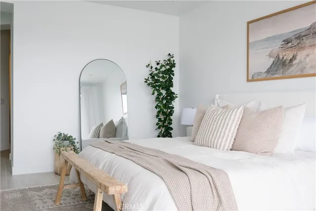 a bedroom with bed and a potted plant