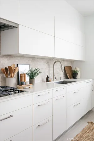 a kitchen with white cabinets and white appliances