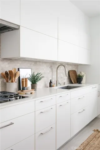 a kitchen with white cabinets and white appliances