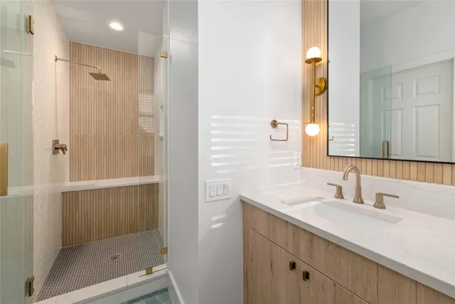 a bathroom with a shower sink and mirror