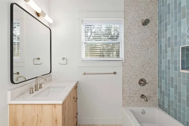 a bathroom with a granite countertop sink a shower and a mirror