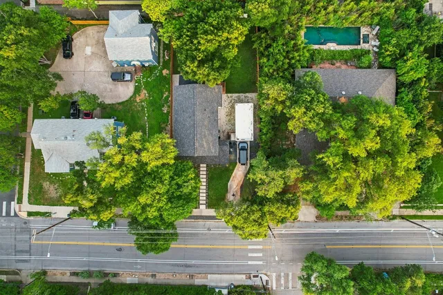 an aerial view of a house with a yard and large tree