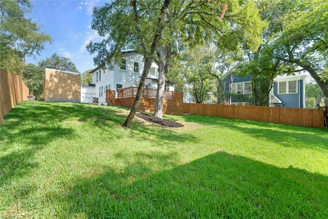 a view of a house with backyard and a tree