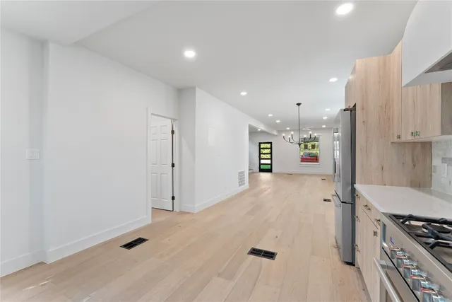 a view of kitchen with stainless steel appliances refrigerator stove microwave and cabinets
