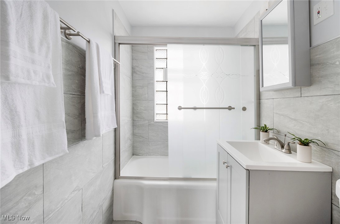 4188 Kirk Road Youngstown, OH 44511 - Photo 21 of 49 Bathroom with tile walls, vanity, and tiled shower / bath