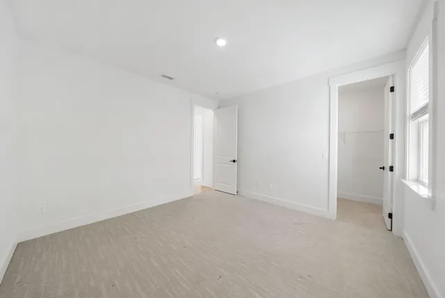 a front view of a house with a yard and potted plants