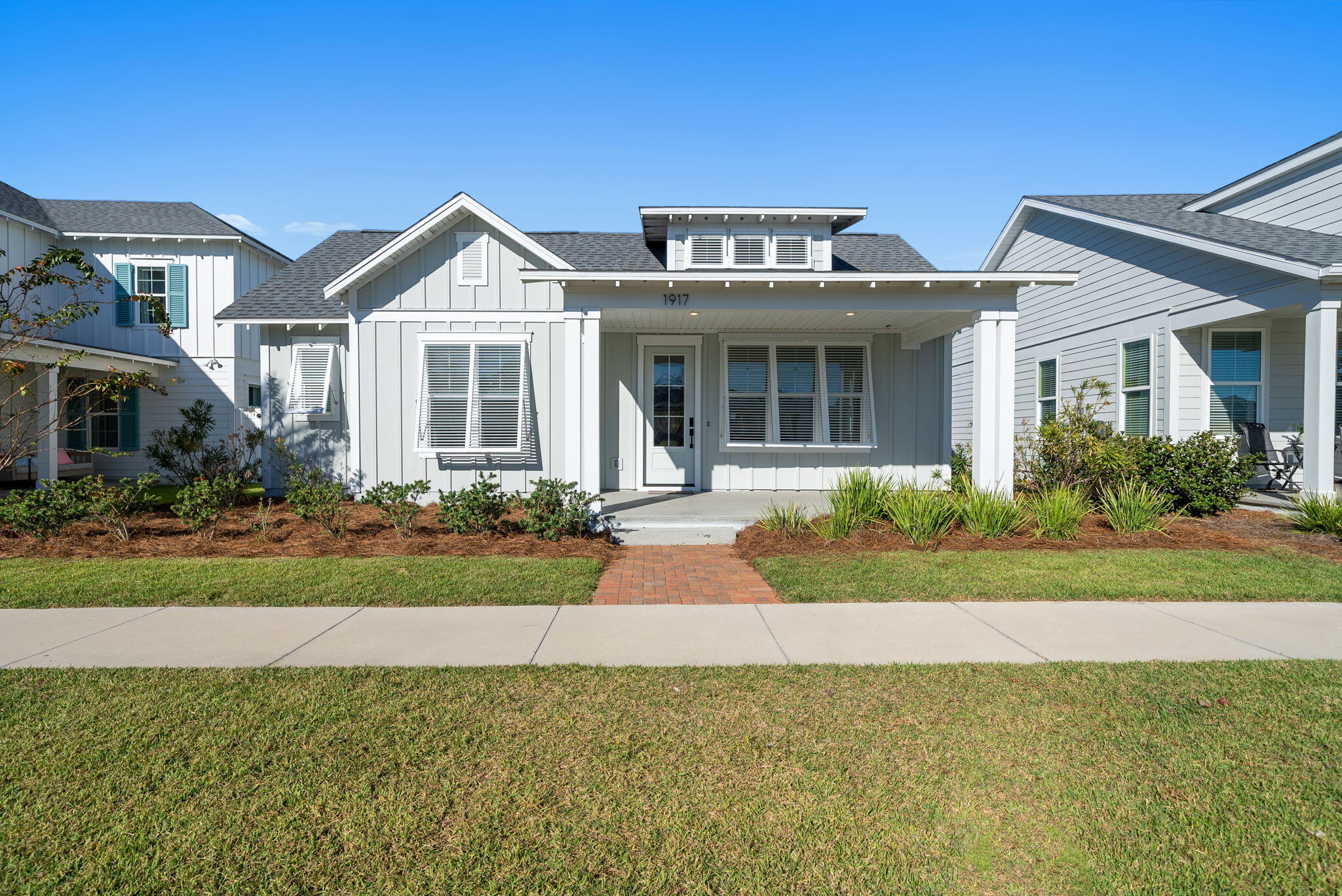 1917 Rushes Avenue Panama City, FL 32405 - Photo 43 of 66 a front view of a house with a yard and potted plants