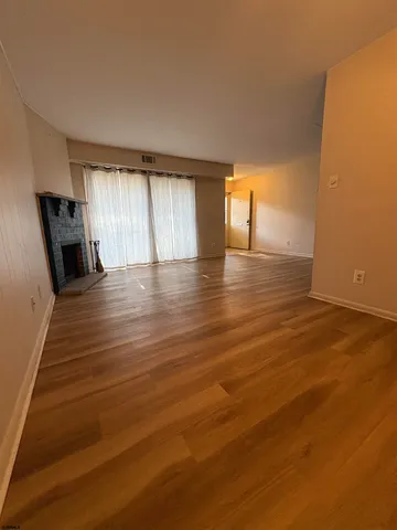 a view of a room with wooden floor and window